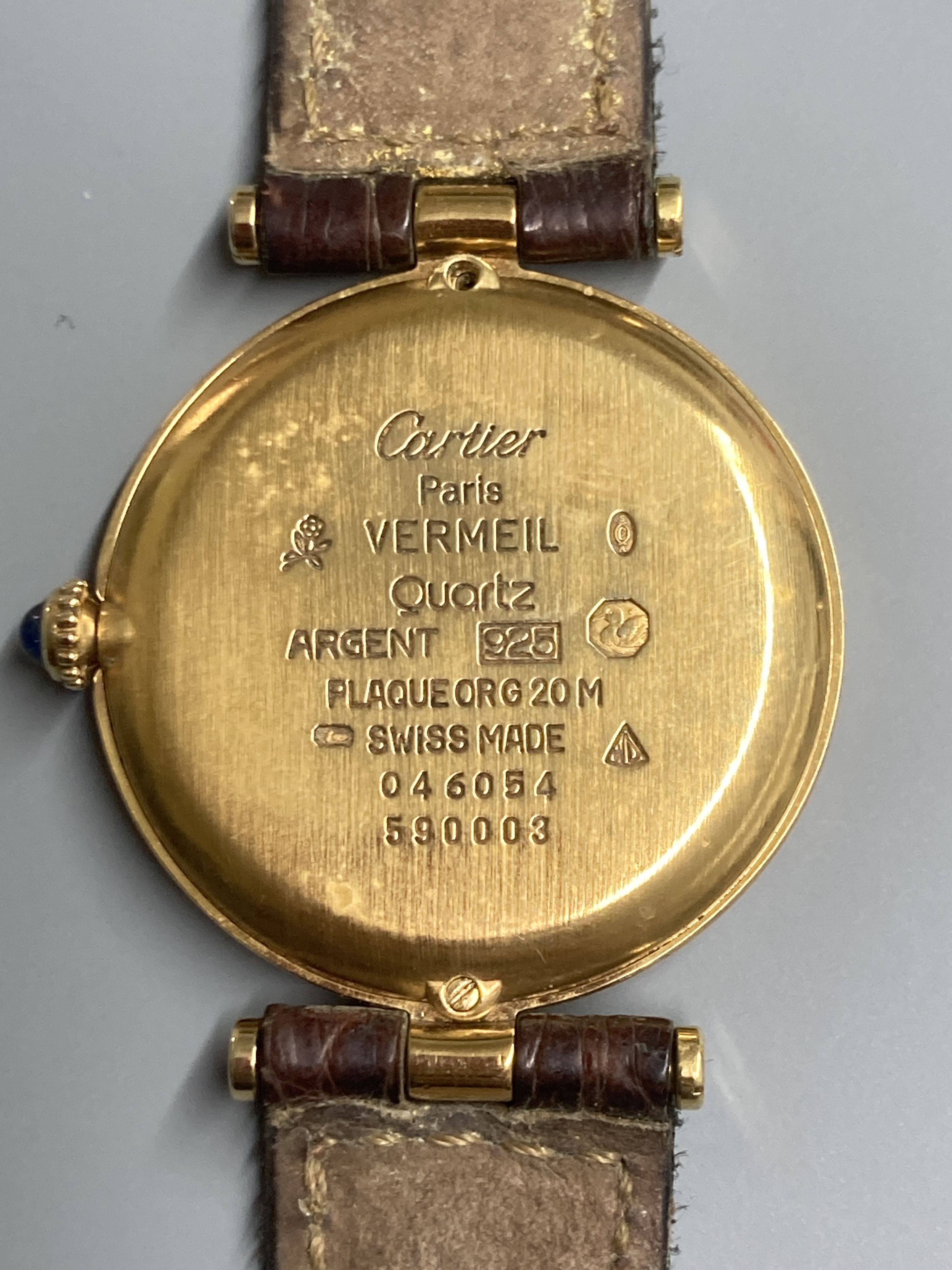 A modern Cartier Vermeil gilt 925 quartz wrist watch, with circular Roman dial and cabochon set crown, on a Cartier leather strap, case diameter 30mm ex. crown.
